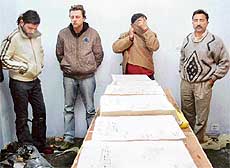 Lio, Jiri, Narender Gupta (from left to right) with seized contraband in NCB custody in Chandigarh on Thursday.  Narcotics Control Bureau officer O.P. Sharma is extreme right. 