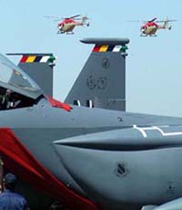 Two Sarang helicopters fly past a US Air Force plane F-15E, during the second day of the 5th Aero-India Show-2005, at Yelhanka Air Force station, near Bangalore, on Thursday. 