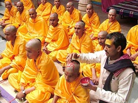 An Acharya of the Mathura Chaturvedi Sanskrit Mahavidhyalaya drawing the Swastik symbol on the head of a disciple