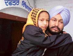 Harjinder Kaur (Komal) with her father outside the Tripri Police post in Patiala on Thursday. 