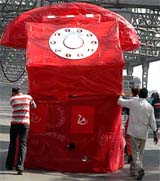 CPI (M) supporters push the replica of a huge telephone made of paper to protest the new telecom policy of the UPA government at Howrah Bridge