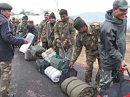 Army men carrying their belongings boarding an Air Force plane for onwards journey to Srinagar