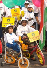 Schoolchildren on their cycles participate in the Save Oil Two-Wheeler Womens Rally