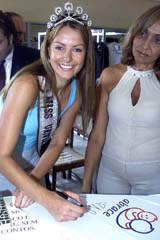 Miss Universe 2004 Jennifer Hawkins of Australia autographs a T-shirt