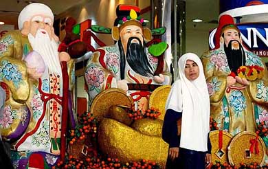 A Muslim woman walks past Chinese New Year decorations on display in downtown Kuala Lumpur