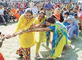 Women participate in a tug of war at Basant Utsav in Leisure Valley, Chandigarh, on Sunday