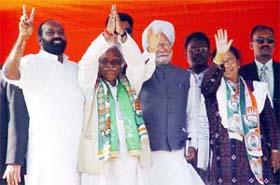 Prime Minister Manmohan Singh and Congress candidates Eva Shamim (Jamshedpur-East) and Ramashreya Prasad (Jamshedpur-West) greet party supporters during an election rally at Jamshedpur, Jharkhand