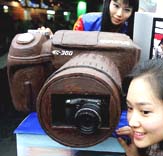 Female employees of the Olympus display the one-meter (39 inches) long model of camera made of chocolate to celebrate Valentines Day in Seoul