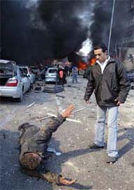 A wounded man lying on the ground asks for help after a massive car bomb explosion in Beirut