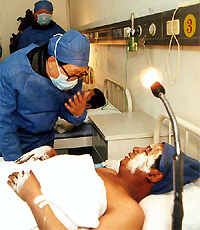 Chinas State Councillor Hua Jianmin (left) visits a miner who was injured in the blast in Fuxin city