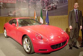 Gianfrancos Alois, Regional Minister for Trade and Industry of Italy, poses for a photograph in front of a famous Italian car, Ferrari, at an exhibition in New Delhi on Wednesday.