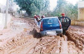 A car stuck up in the muddy road at Rajgarh village.