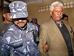Nepali Congress spokesman Arjun Narshing K.K. is escorted by the police from his party office in Kathmandu on Wednesday
