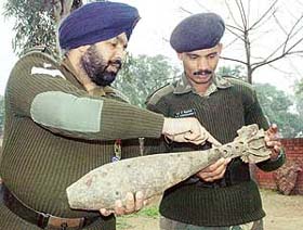Experts from an Army bomb disposal unit inspect an old bomb found in a nearby village before disposing it of in Chandigarh