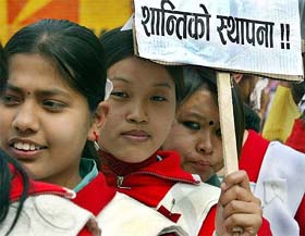 A Nepali schoolgirl holds a placard demanding peace in Nepal during a rally in Kathmandu