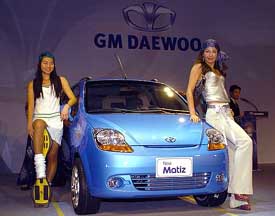 South Korean models pose along side GM Daewoos new Matiz mini during an unveiling ceremony in Seoul on Monday. 