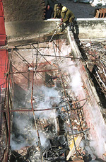 A Delhi Fire Service jawan trying to put out fire at South Extension in the Capital on Monday