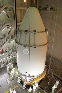 Technicians work on a fairing containing a multifunctional transport satellite