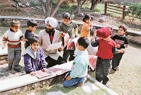 Painter R.M. Singh with children of The Mango Grove School in Panchkula on Tuesday.