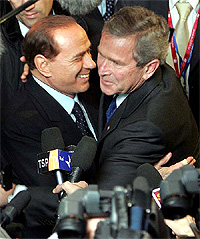 US President George W. Bush and Italian Prime Minister Silvio Berlusconi embrace each other at the European Council in Brussels