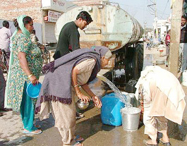 Residents of Lal Singh basti in Bathinda filling their utensils with water supplied by a tanker.