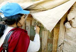 A Pakistani census staff marks the house of an Afghan family, which has registered for the census, in an Afghan refugee camp at the outskirts of Islamabad on Sunday.