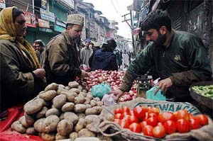 A roadside vegetable vendor busy attending customers at Maharaj Bazaar