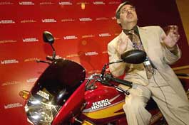 Managing Director of Hero Honda Motors Ltd. Pawan Munjal gestures as he conducts an interview while sitting on the new Hero Honda Super Splendor motor cycle after a launch ceremony in Mumbai on Thursday.