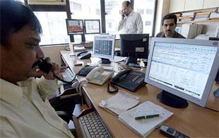 Stock dealers trade shares at their office in Mumbai on Friday. The stock market is at all-time record high with the Sensex at 6,849.48 points, up 0.87 per cent over its previous close of 6784.72. Overseas funds have been buying heavily after P. Chidambaram announced a growth-oriented Budget.