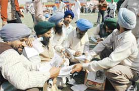 Farmers going through the new literature brought out by Panjab Agricultural University on the occaison of annual kisan mela in Ludhiana