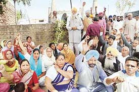 Residents of Dadu Majra sitting on a dharna in front of religious place against Municipal Corporations move to demolish unauthorised religious places in Dadu Majra on Saturday. 