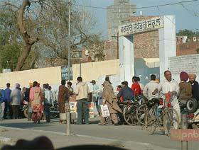 Abetters of copying gather outside an examination centre at Government Senior Secondary School, Kot Baba Deep Singh