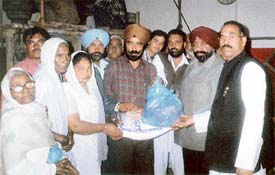 Members of the Punjabi Nishkam Seva Dal distribute ration to needy women at a function in Ludhiana