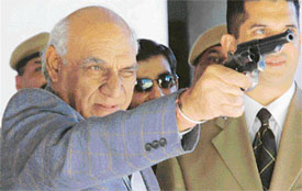 Bollywood producer and director Yash Chopra tries his hand at a small fire-arm at a museum in the Punjab Police Academy, Phillaur, on Monday