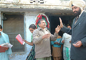 A school employee pleads with the in charge of a flying squad of the education Board after a surprise raid in Ajnala on Monday. The students, helping in preparing material for mass copying, are seen fleeing.