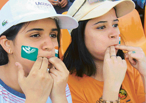 Two young girls blow whistles to cheer cricketers at the PCA stadium, Mohali, on Thursday