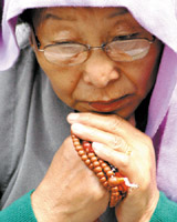 A Tibetan woman praying during a demonstration on the occasion of 46th anniversary of the Tibetan National Uprising Day against the Chinese occupation of Tibet at Jantar Mantar in the Capital on Thursday.