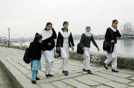 Students return from school in Srinagar on Monday. Schools in the region reopened after nearly three months due to harsh winter. 