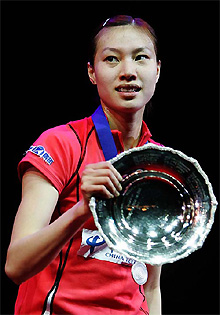 Chinas Xie Xingfang holds her trophy after defeating Zhang Ning of China in the final of the womens singles at the All-England Open Badminton Championships in Birmingham on Sunday