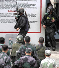 Philippine policemen leave a jail after storming it in Manila on Tuesday. The police shot dead 17 prisoners as they stormed a jail in Manila on Tuesday to end a day-long stand-off with a group of Islamic militants who had snatched weapons from guards and killed three of them. 
