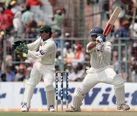 Rahul Dravid executes a shot as Kamran Akmal watches during the first days play of the second Test in Kolkata on Wednesday