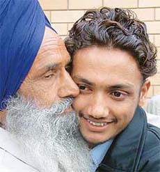A youth released from prison by the Pakistani authorities meets his father at Wagah