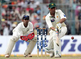 Younis Khan executes a shot as Dinesh Kaarthick watches during the second days play of the second Test in Kolkata on Thursday