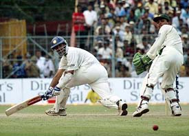 Rahul Dravid plays a shot as Kamran Akmal looks on during the third days play of the second Test in Kolkata on Friday