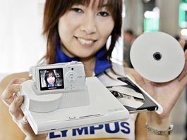 An employee of Japanese camera company Olympus displays the new digital camera, i:robe IR-300