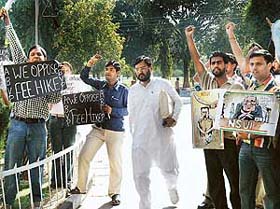 Senate member Ashok Goyal on the way to attend the Senate meeting as ABVP and NSUI workers protest against the fee hike