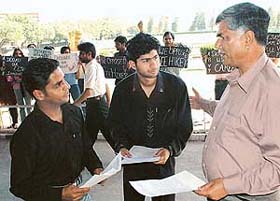 Students of Dhanwantry Ayurvedic College give a memorandum to Senate member Satish Sharma before he goes to attend a meeting of the PU Senate