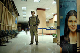 A security officer stands inside the Parliament Street branch of the State Bank of India in New Delhi on Tuesday. The bank wore a deserted look due to a nationwide bank strike call.