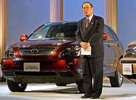 Toyota Motor Corp. President Fujio Cho launches the automakers two new gasoline-electric hybrid cars, Harrier Hybrid and Kluger Hybrid. He poses with Harrier Hybrid at a press conference in Tokyo on Tuesday. The hybrid cars feature high-power Toyota Hybrid System II (THS II) and E-Four (electric 4-wheel drive) system. Toyota says the new-generation Harrier and Kluger achieve the worlds highest level of fuel efficiency in their class as well as clean exhaust emissions.
