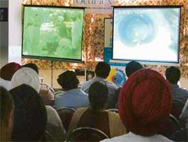 Participants at the state-level phacoemulsification workshop watch live eye surgery on TV screen in Ludhiana